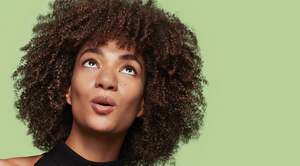 A woman looking up at her coily hair